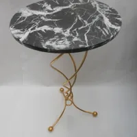 Hllywood regency table . Black marble top guilded base